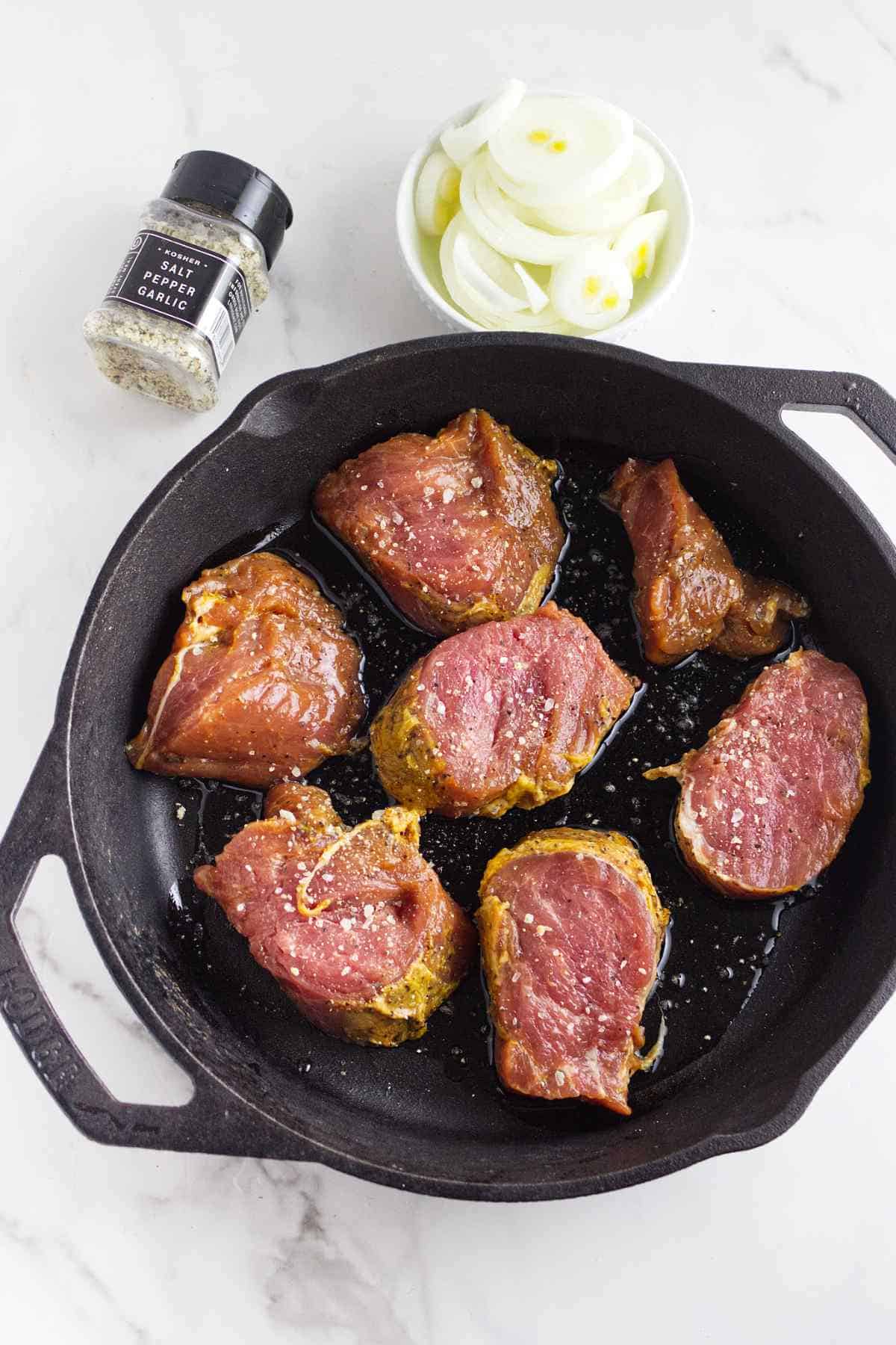 medallions searing in a hot skillet.