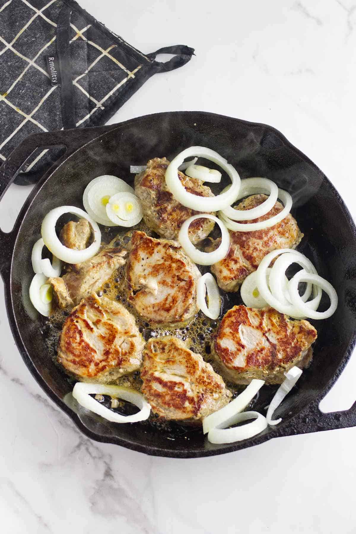 browned meat flipped and with onions added to pan.