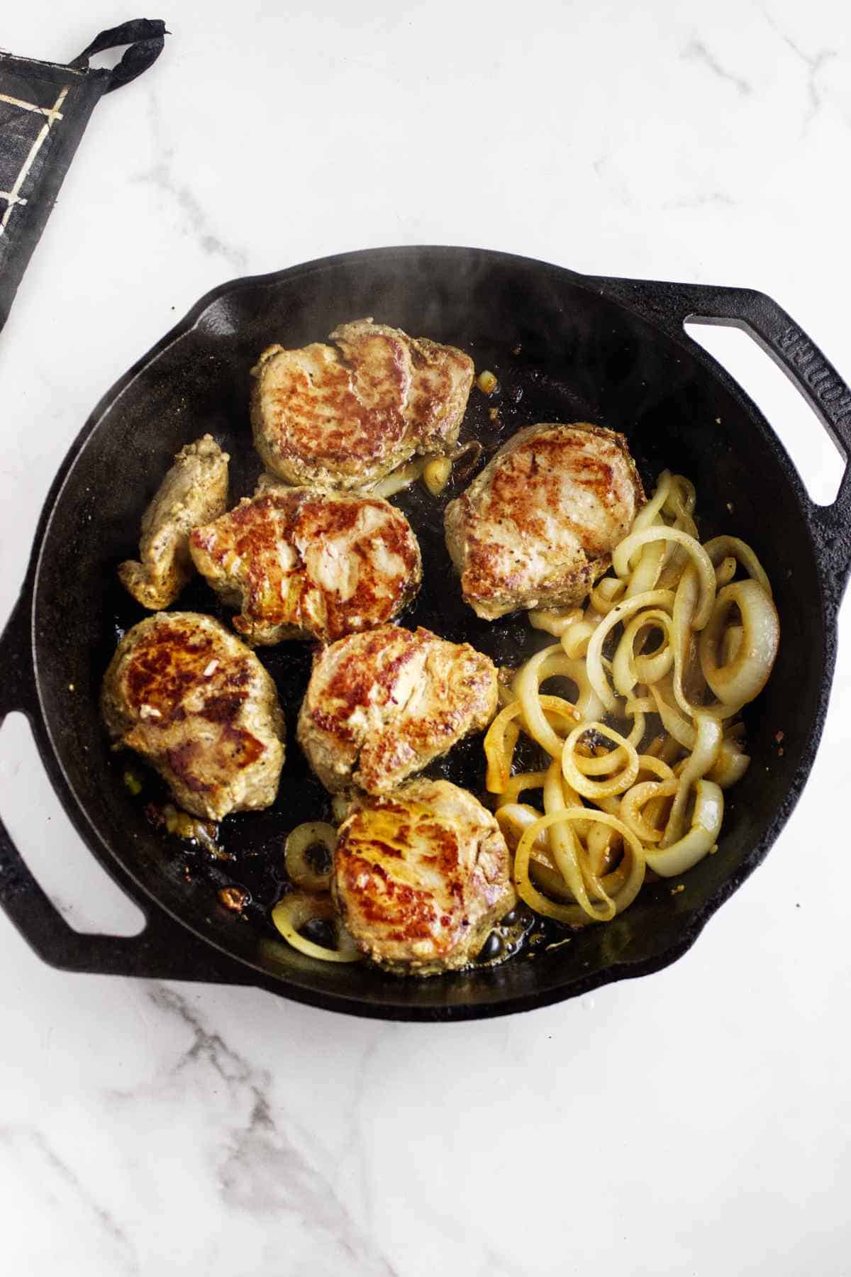 cast iron seared pork tenderloin medallions with onions.