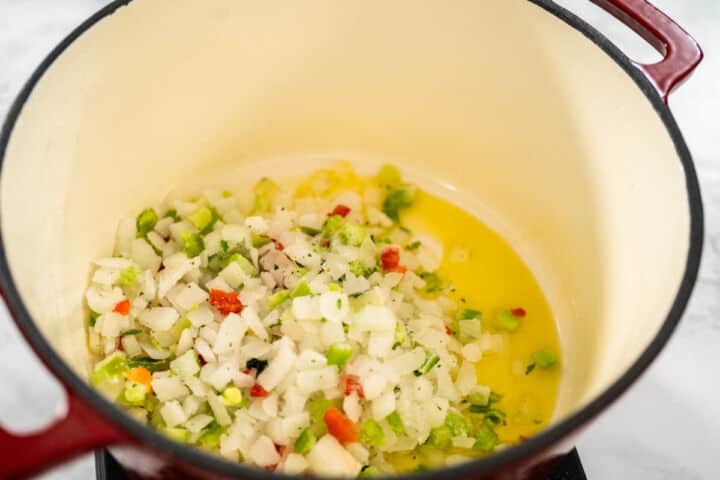 Onion, carrots, celery, and thyme sauteing in olive oil for chicken fideo soup.