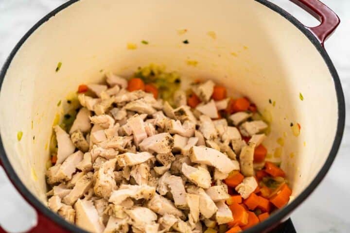 Chicken and vegetables simmering in broth for Mexican chicken fideo soup.
