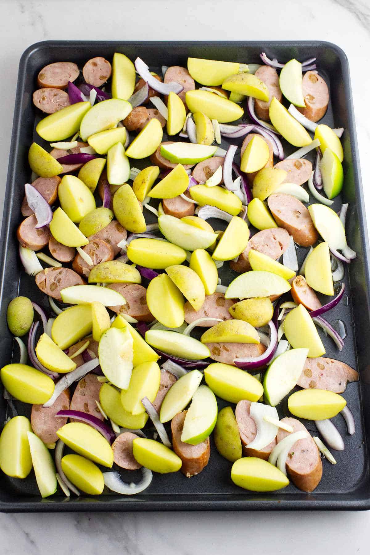 potatoes and apples added to baking pan.
