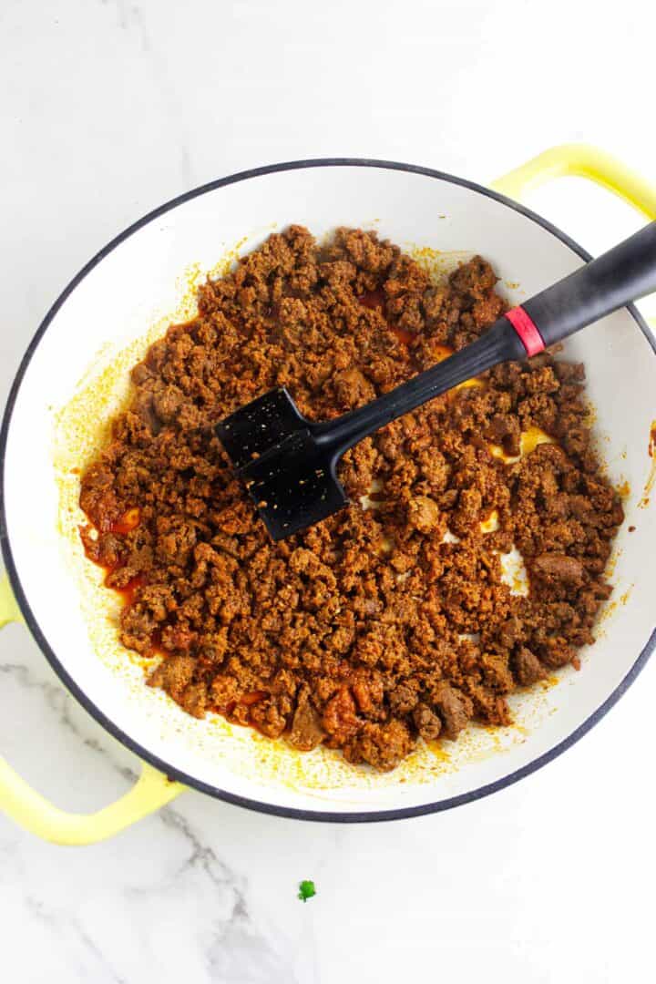 Mexican chorizo cooking in a skillet and breaking apart as it browns.