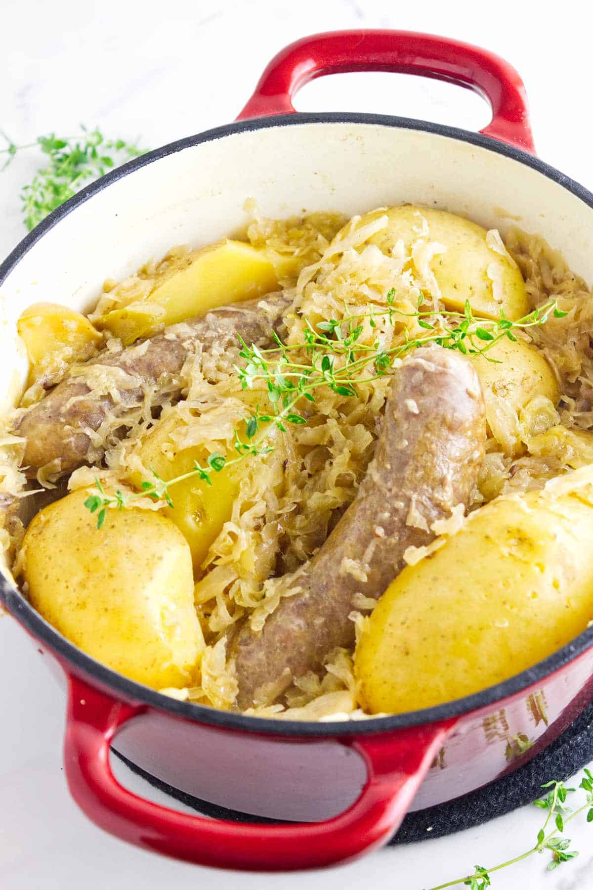 German bratwurst, potatoes, and sauerkraut in a Dutch oven.