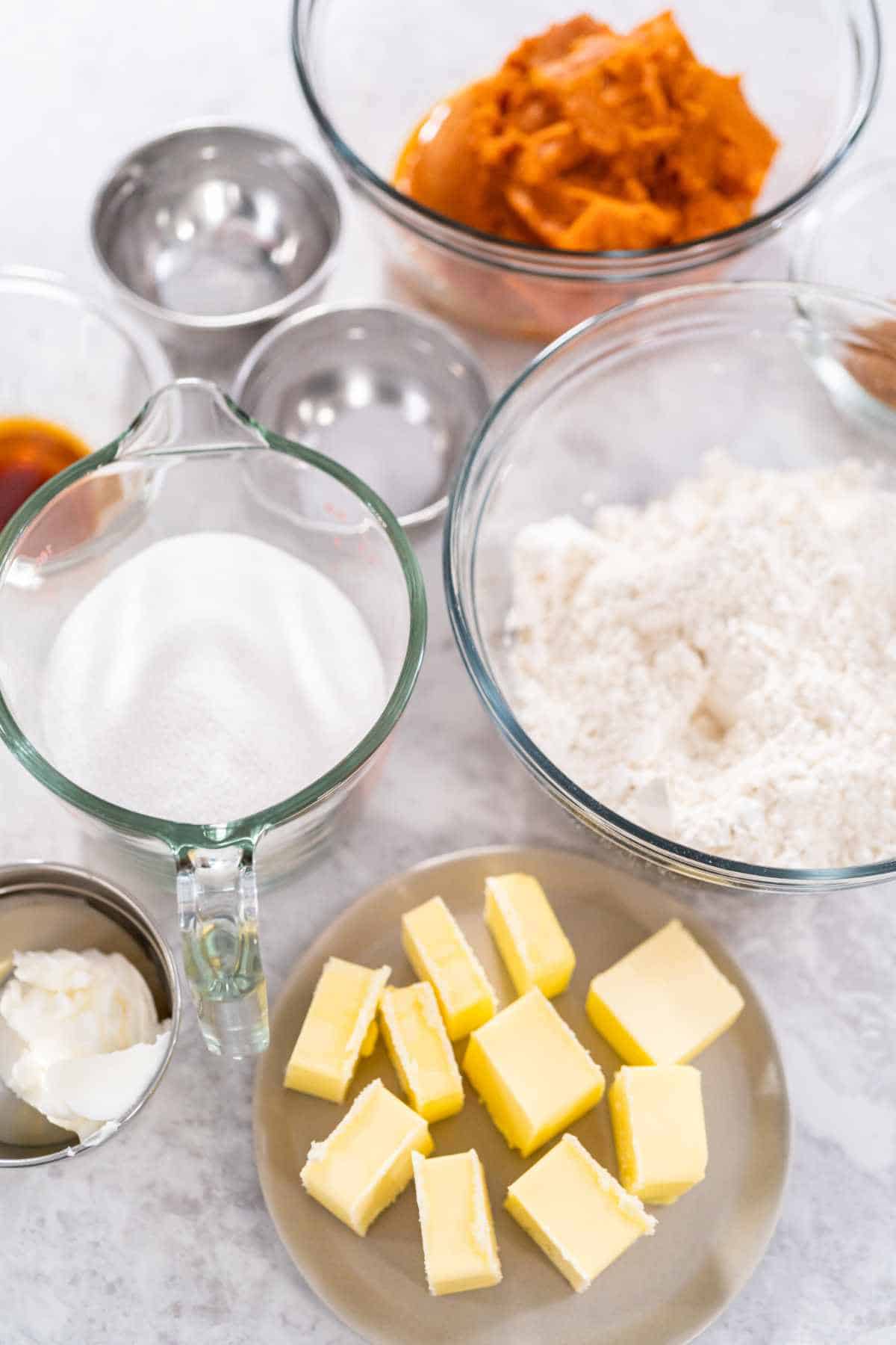 Measured ingredients in a glass mixing bowls to bake sweet pumpkin scones.