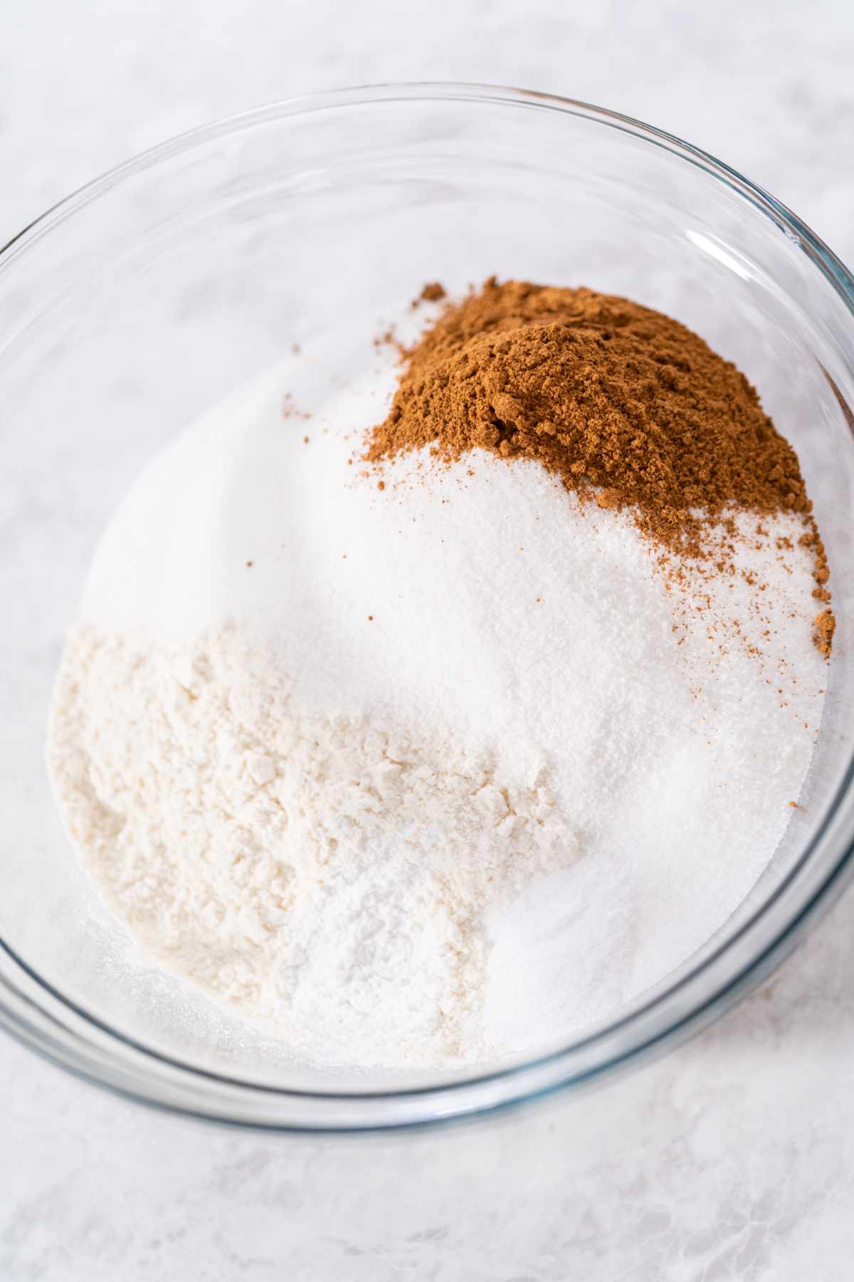 Mixing ingredients in a glass mixing bowl to bake quick bread.