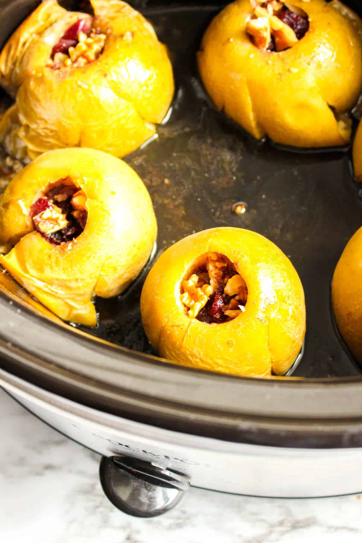slow cooker baked apples stuffed with cranberries and walnuts.
