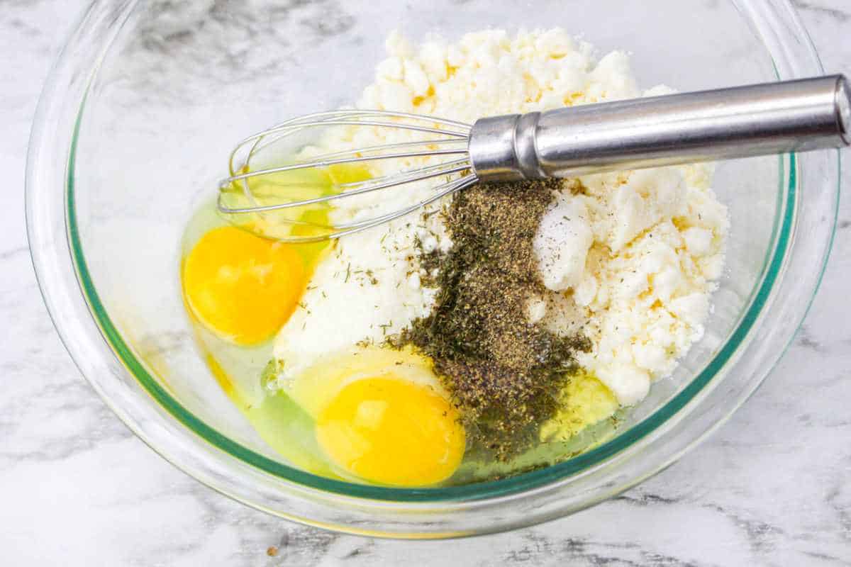 eggs, feta, and seasonings in a bowl.