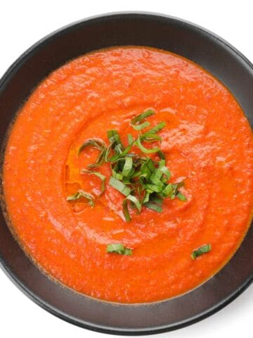 Bowl of tomato cream soup isolated on white background for Fall Soup Round up.