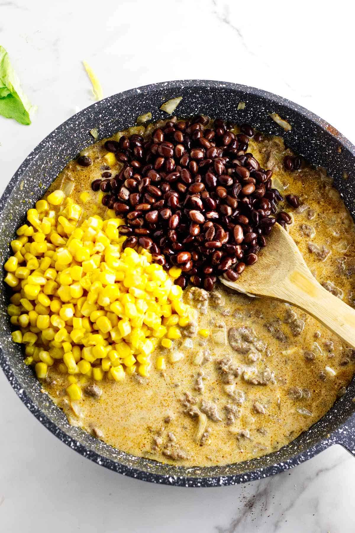 corn kernels and black black beans added to ground beef mixture.