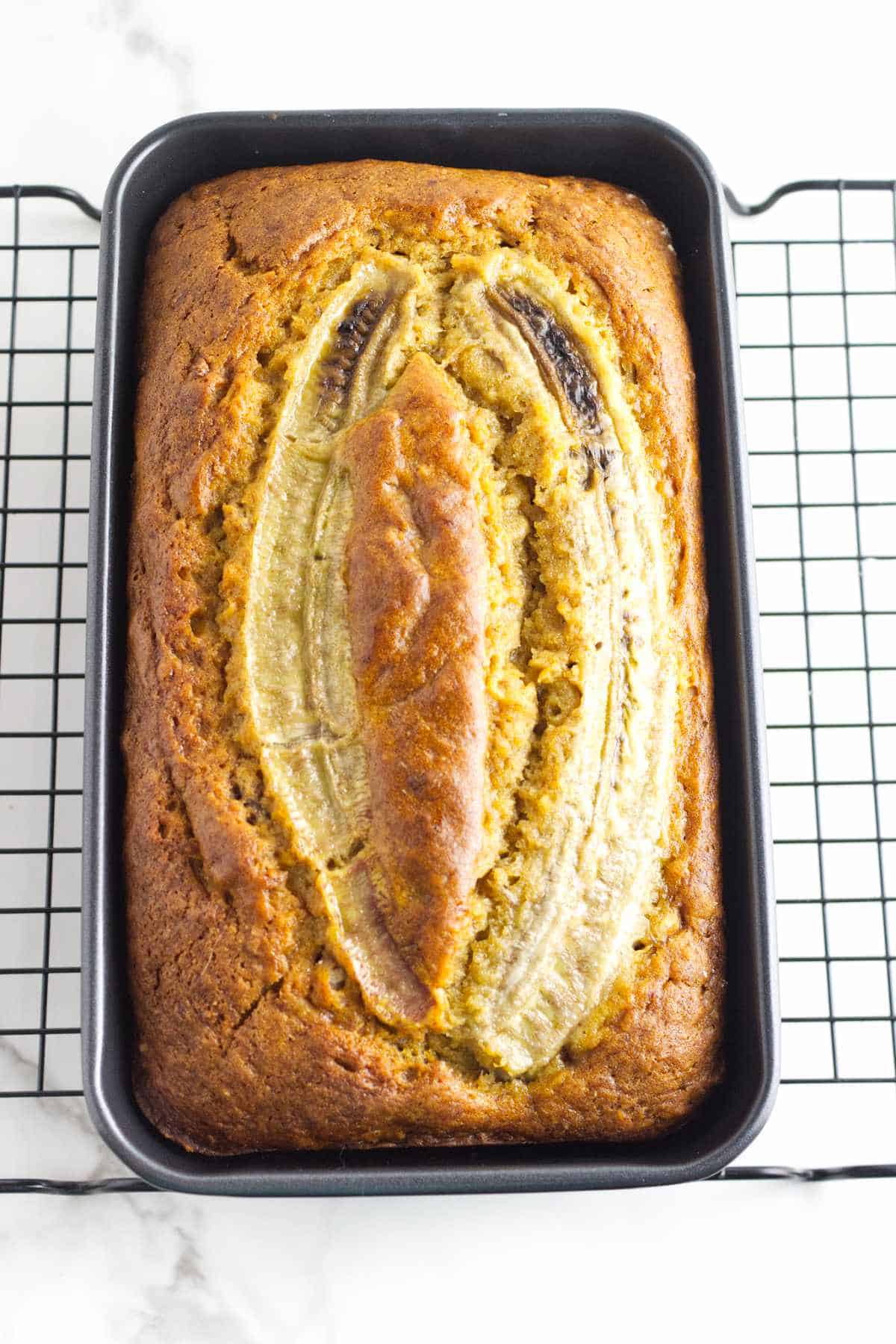 golden browned baked banana bread using self rising flour cooling on a rack.