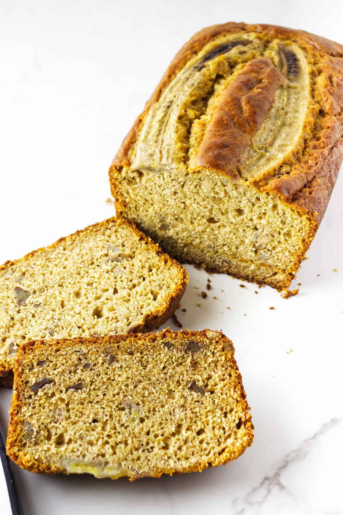 sliced cooled banana bread on a marble countertop.