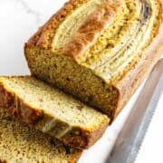 sliced cooled banana bread on a marble countertop.