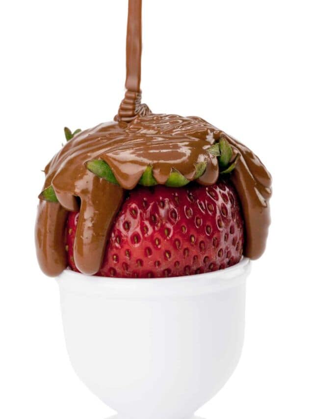 chocolate syrup falling on strawberry fruit.