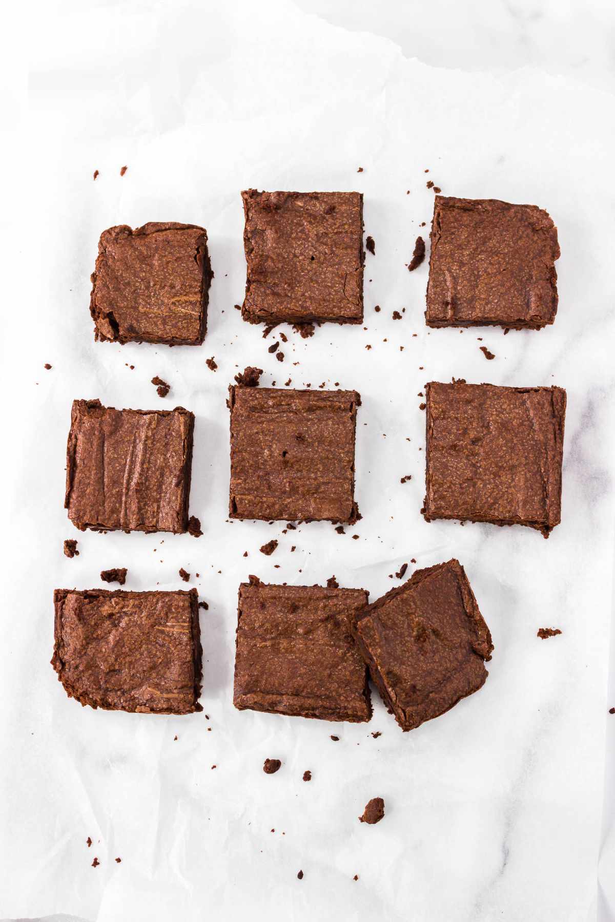 nine Hershey cocoa  brownies freshly cut from pan on a white marble background