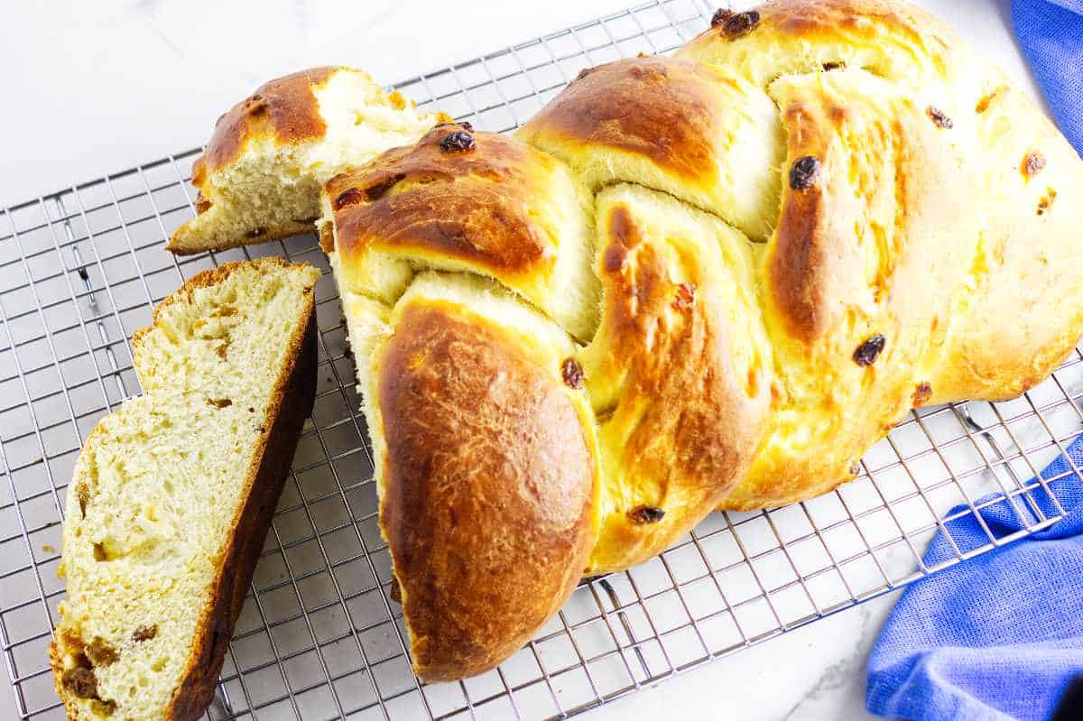 baked braided bread with raisins on a cooling rack.