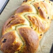 baked challah with raisins on a baking sheet.