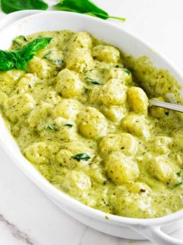 oval baking dish serving creamy pesto gnocchi.