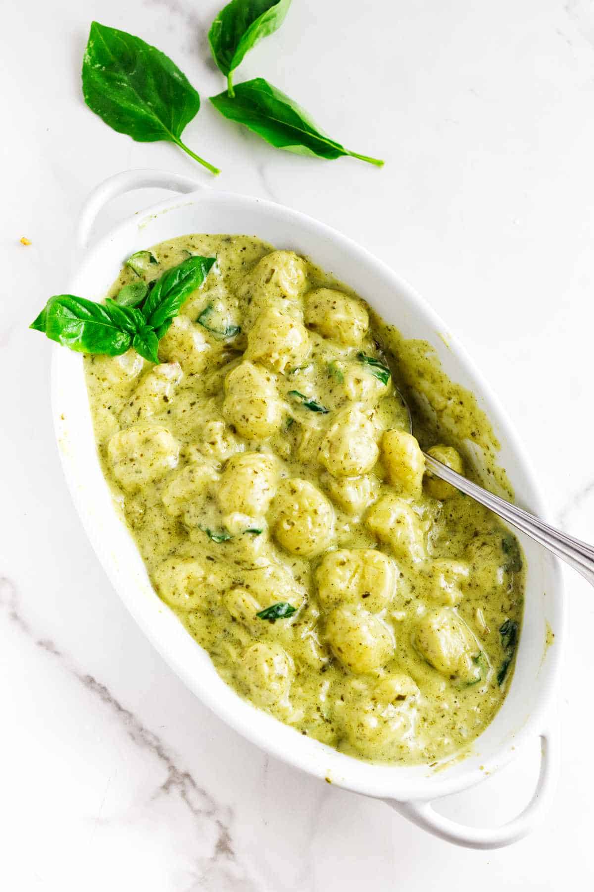 oval baking dish serving creamy pesto gnoochi.