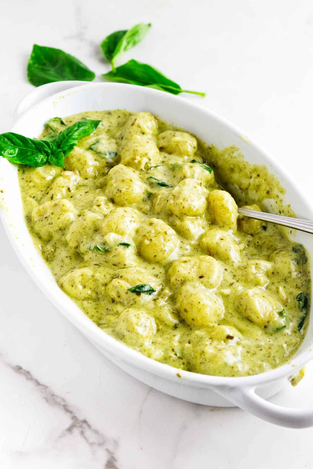 oval baking dish serving creamy pesto gnoochi.