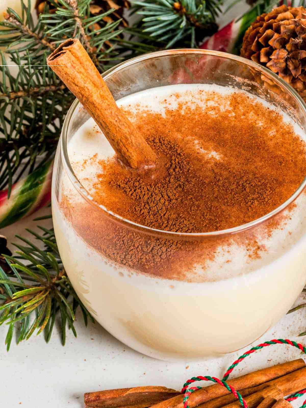 cinnamon sprinkled on top of a glass of eggnog.