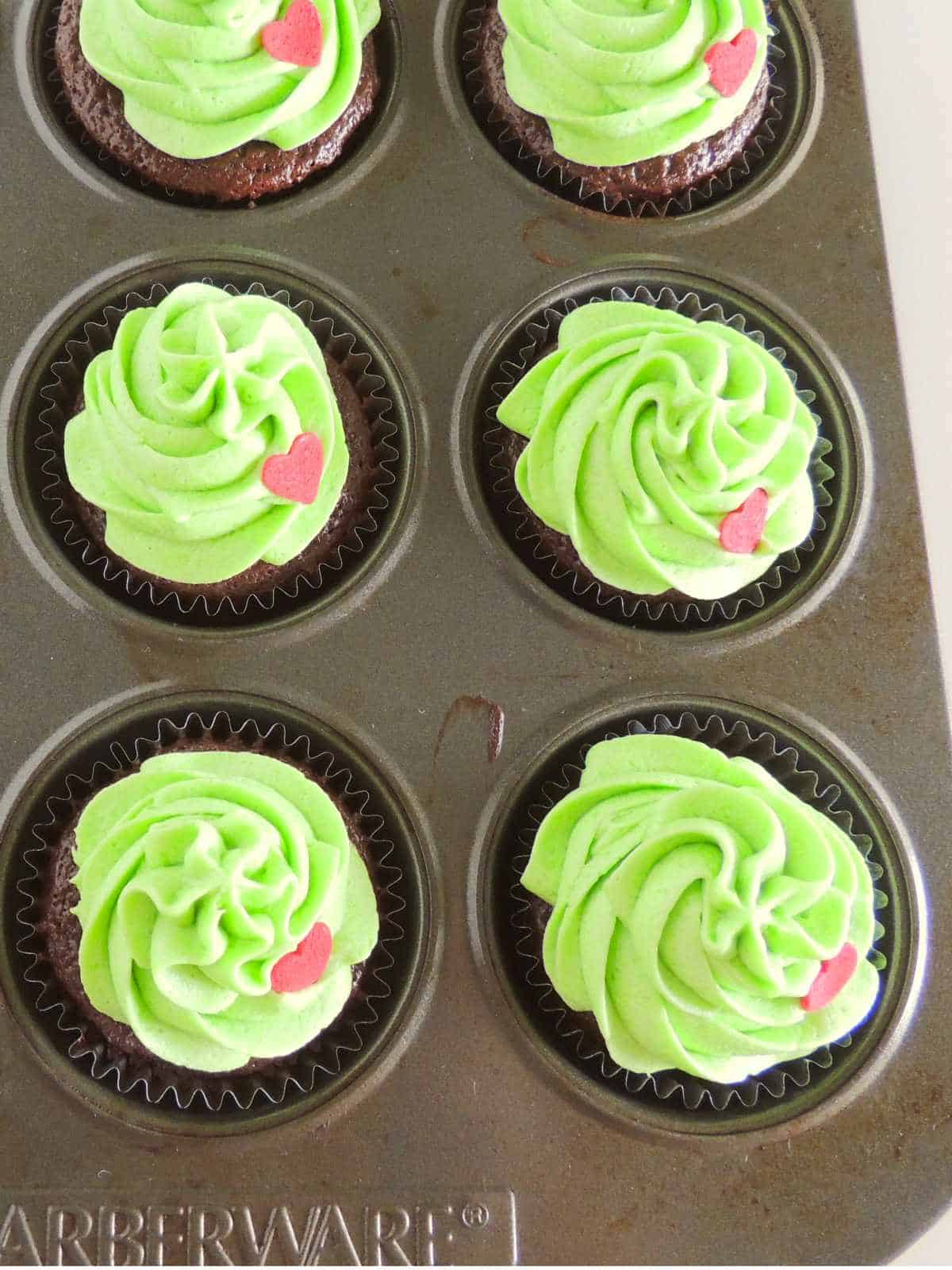 Red candy hearts on grinch green buttercream iced cupcakes.