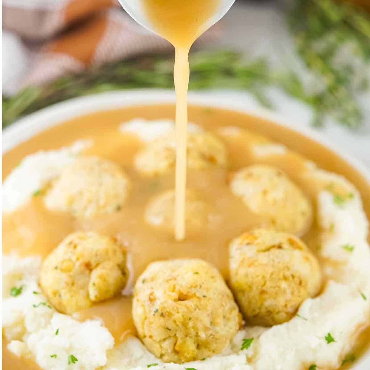 turkey meatballs on mashed potatoes with gravy drizzled on top.