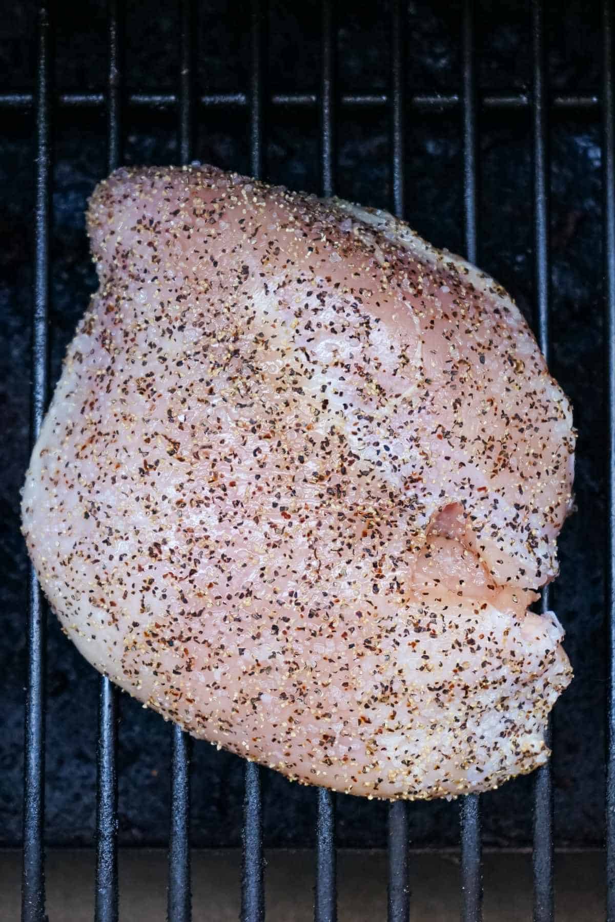 seasoned turkey breast on a smoker grill.