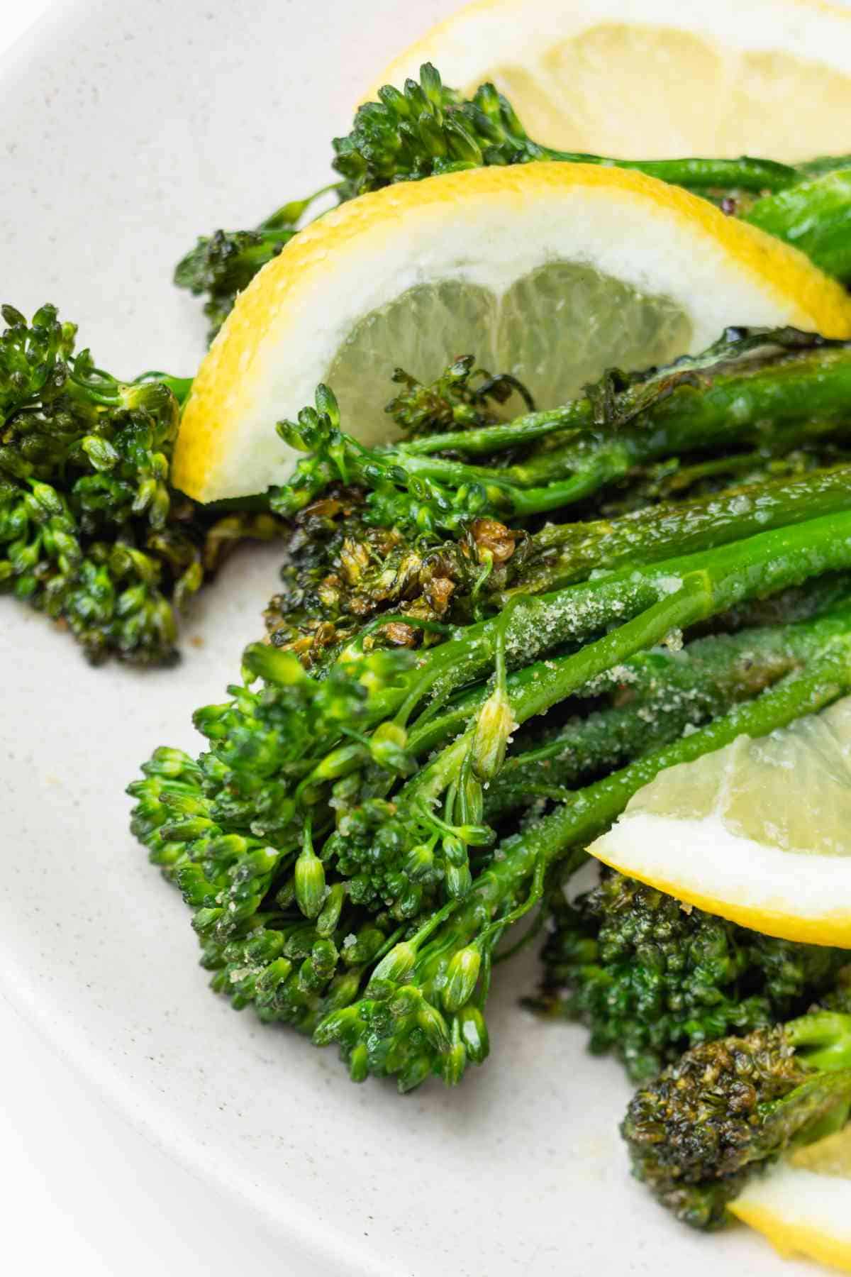 Air fried fresh broccolini with lemon on the plate.
