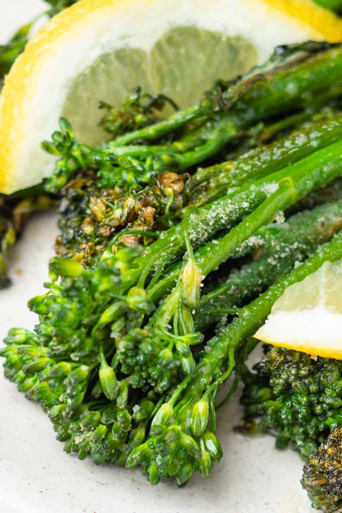 Air fried fresh broccolini with lemon on the plate.