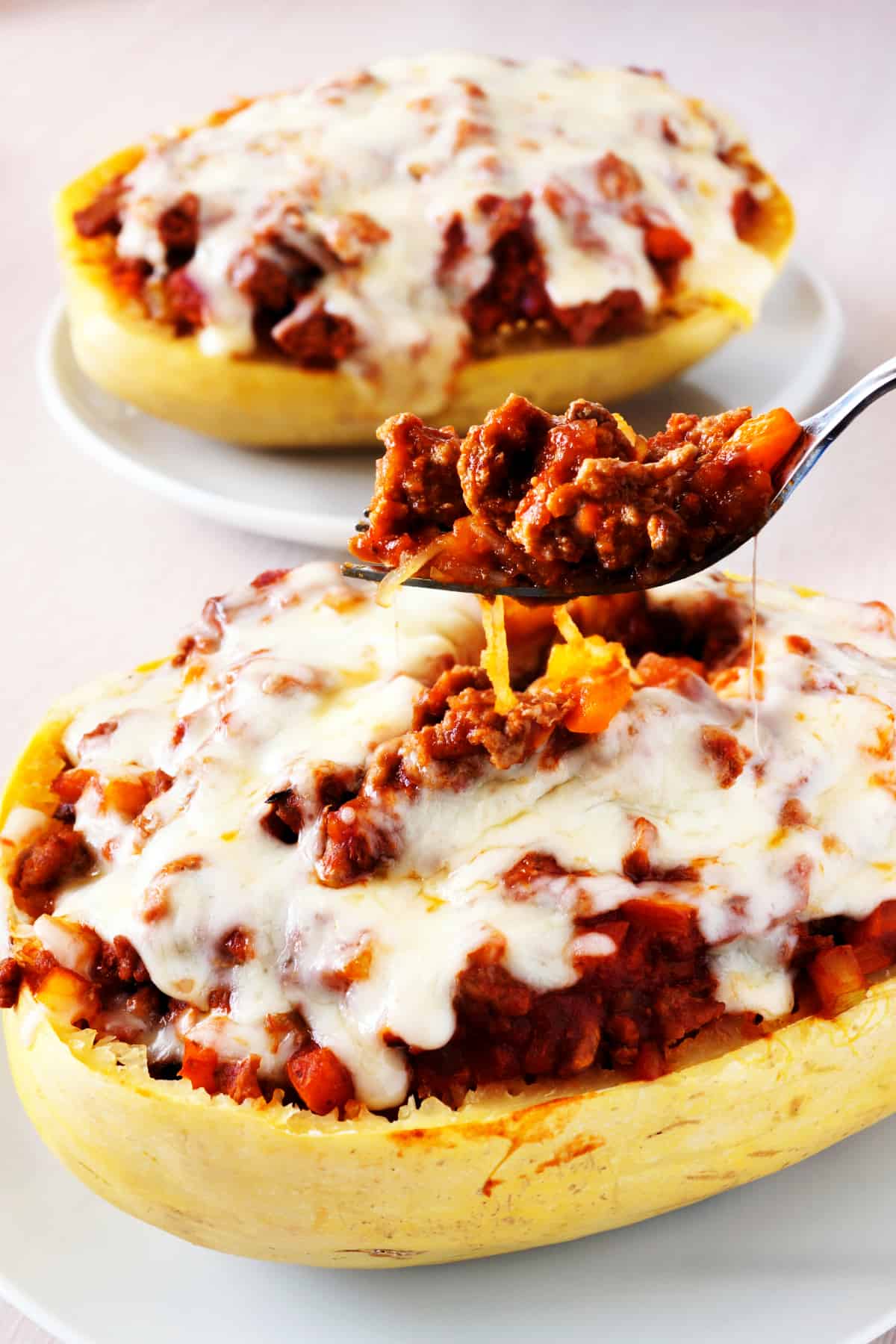 Fork full of spaghetti squash baked with lean ground turkey, peppers, tomato sauce and melted mozzarella cheese.