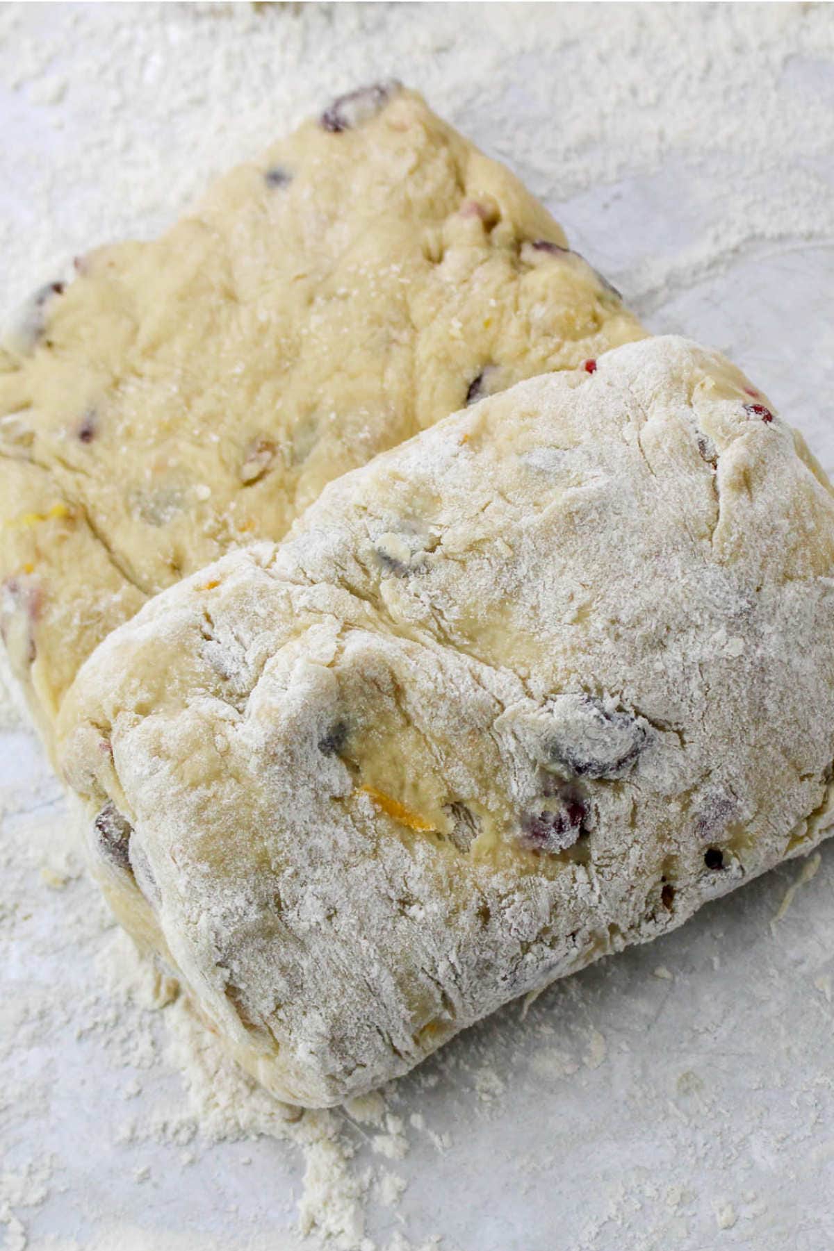 bread dough mixed with dried fruit getting rolled up.