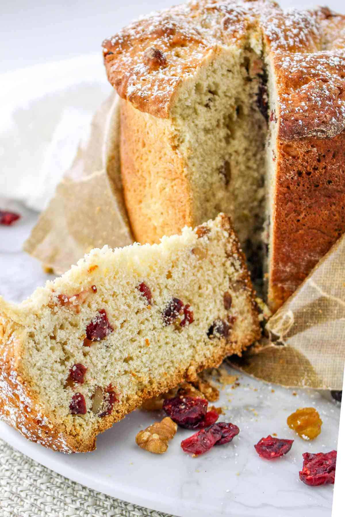 Italian fruit cake with a slice cut and laying on a plate.