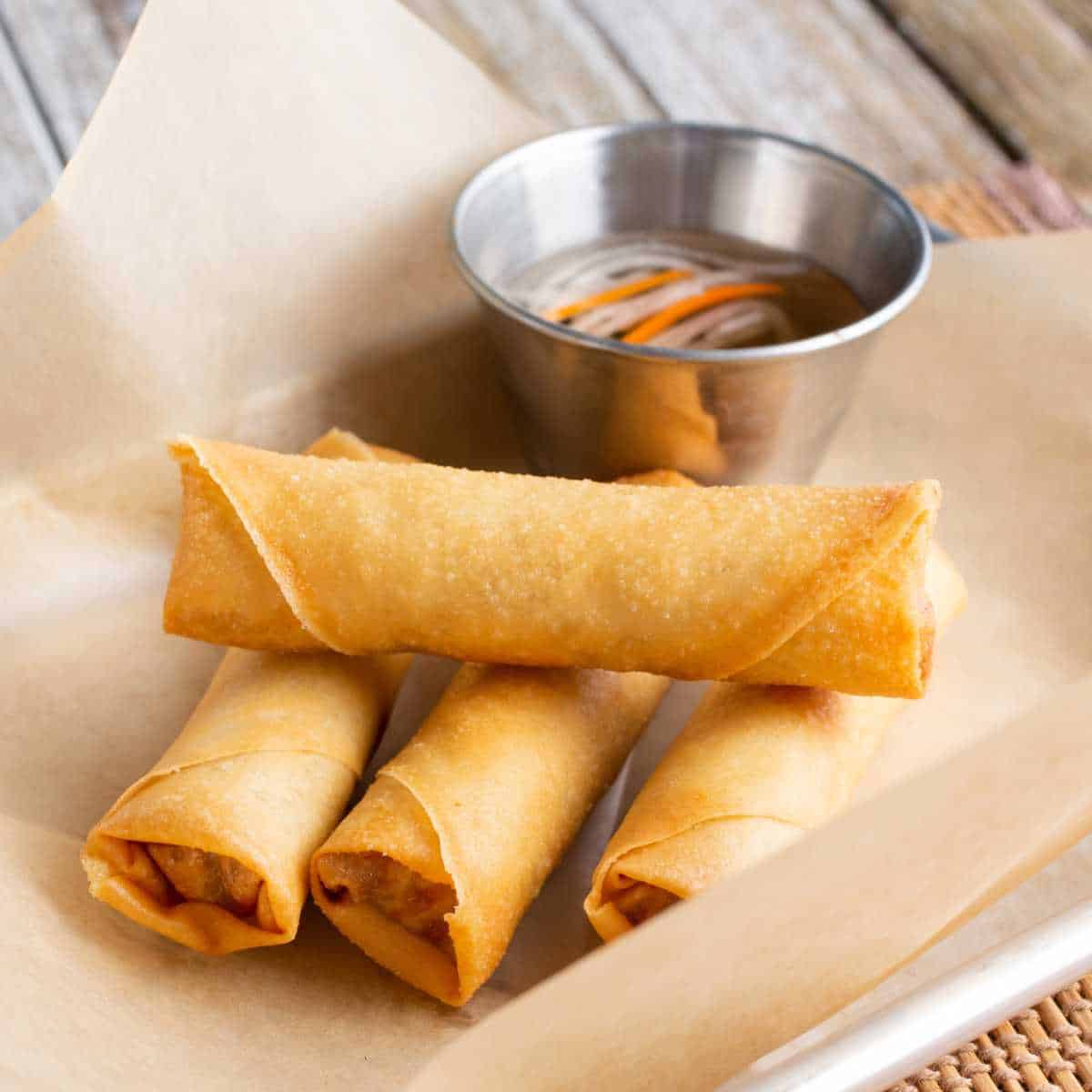 tray of lumpia served with dipping sauce.