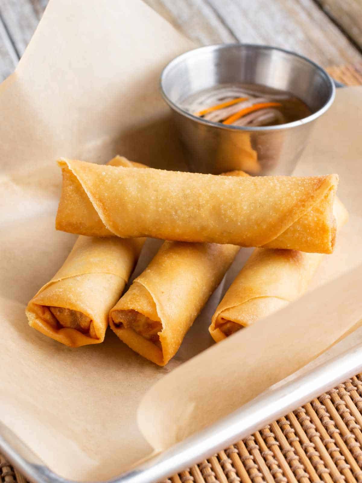 Tray of crispy lumpia served with dipping sauce.
