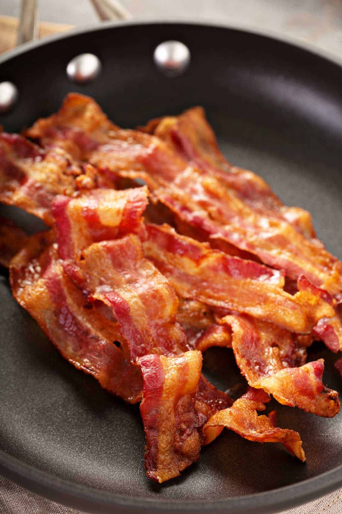 cooked crisp bacon in a skillet.