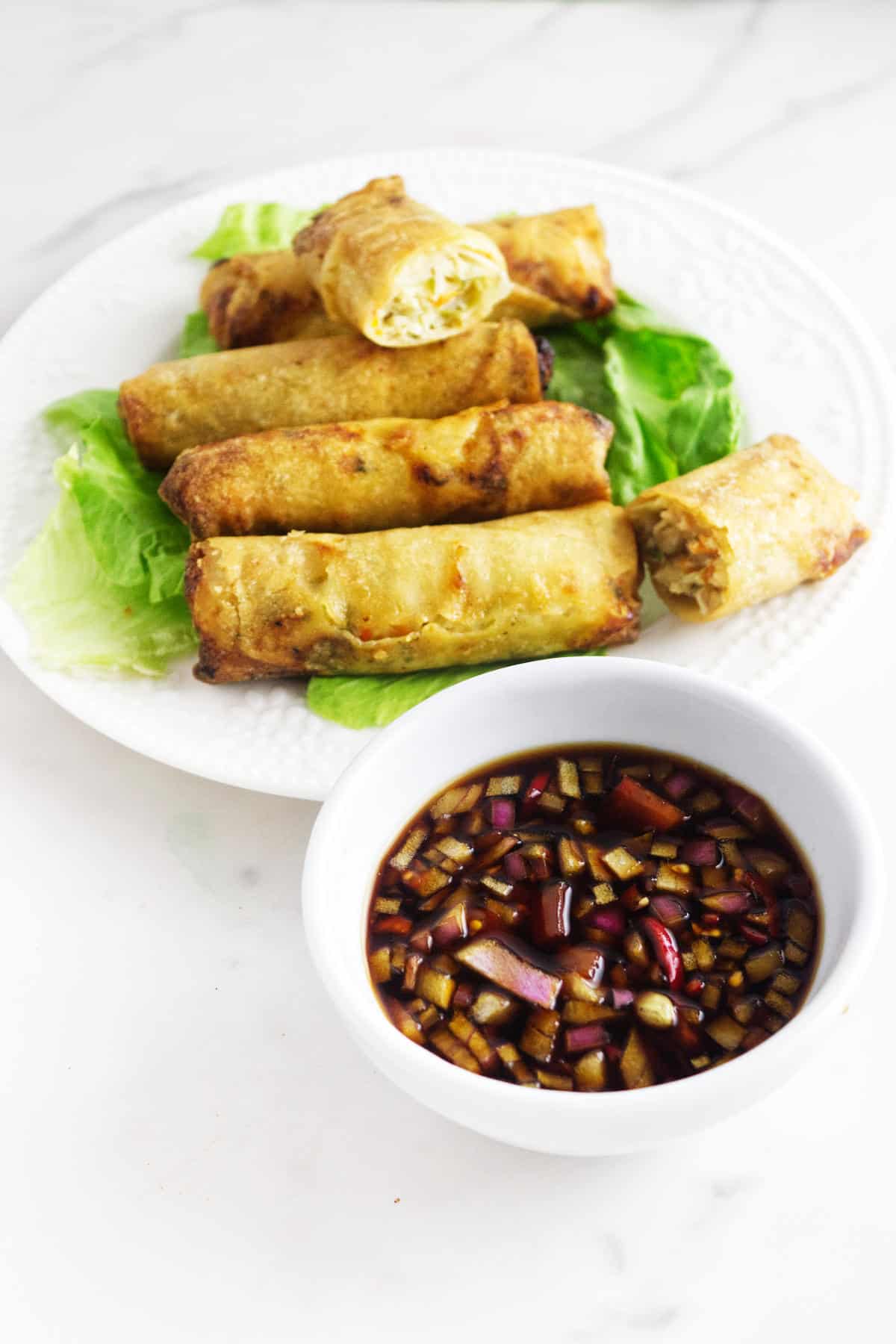 plate of lumpia and a bowl of sawsawan lumpia dipping sauce.