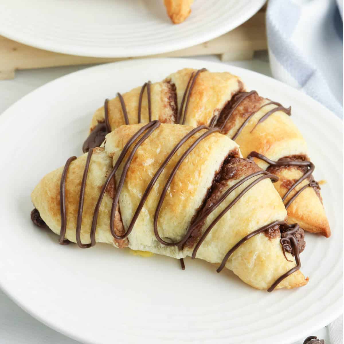 baked crescent rolls with Nutella drizzled on them.