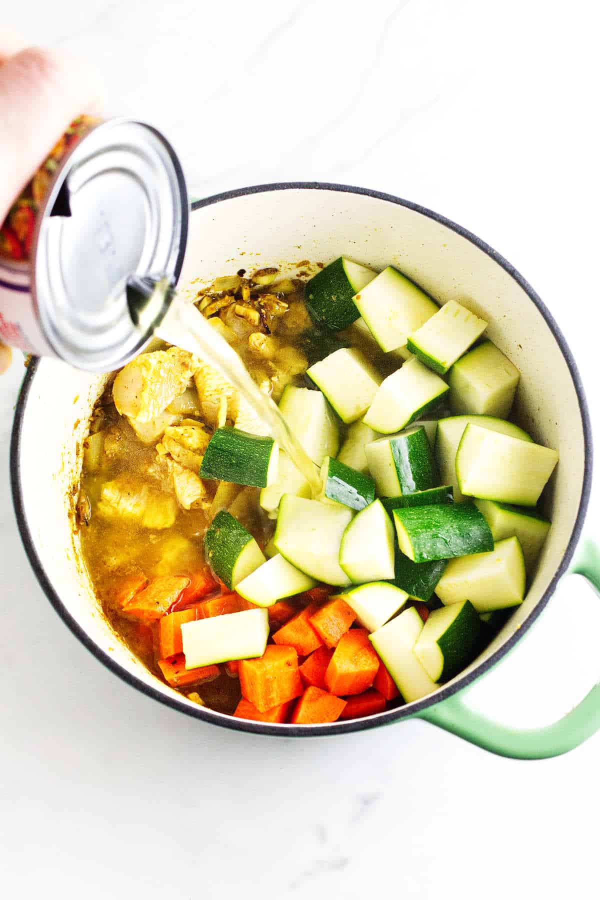 zucchini, carrots, and broth added to soup pot.