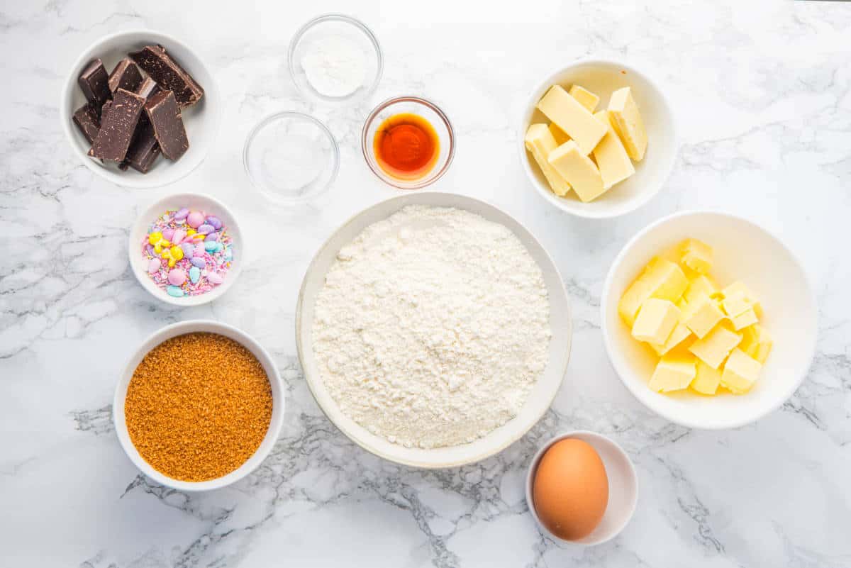 sugar cookie ingredients on a white marble counter.