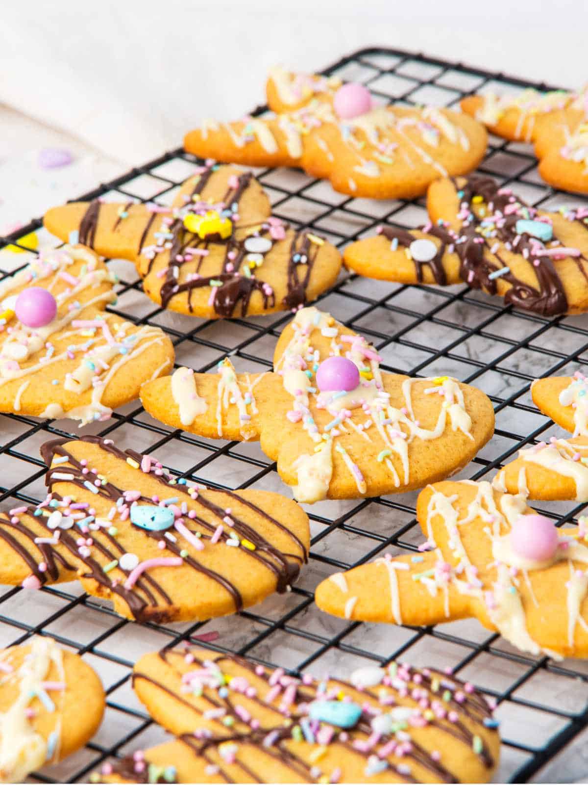 white and dark chocolate drizzled bunny shaped Easter sugar cookies on a cooling rack.