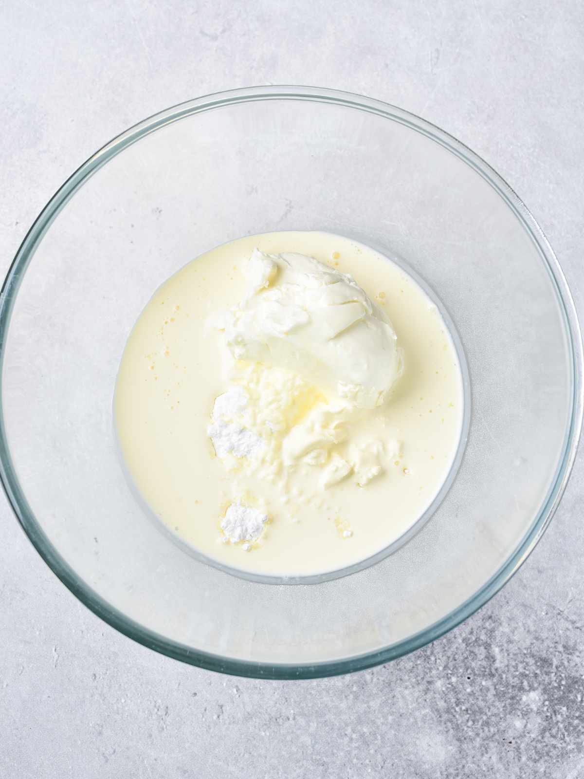 Cream cheese and heavy whipping cream in a bowl.