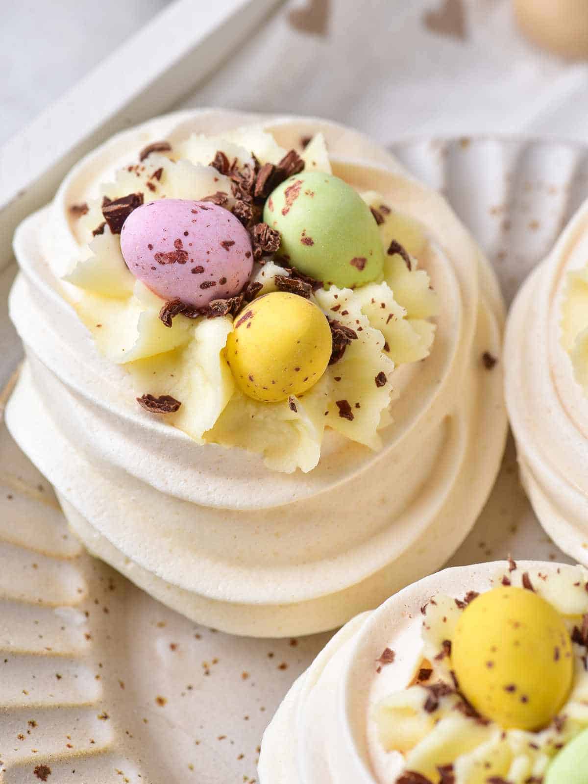 Filled mini Easter Pavlova nests with cheesecake filling and Cadbury Mini eggs.