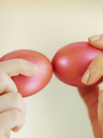 Closeup on tapping with red Easter eggs playing a game of Tsougrisma, the Greek Easter egg game.