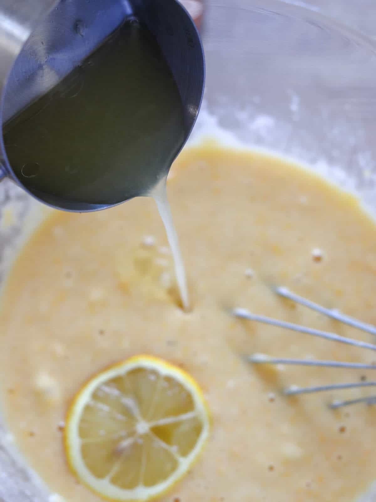 Adding lemon juice to batter in a bowl.