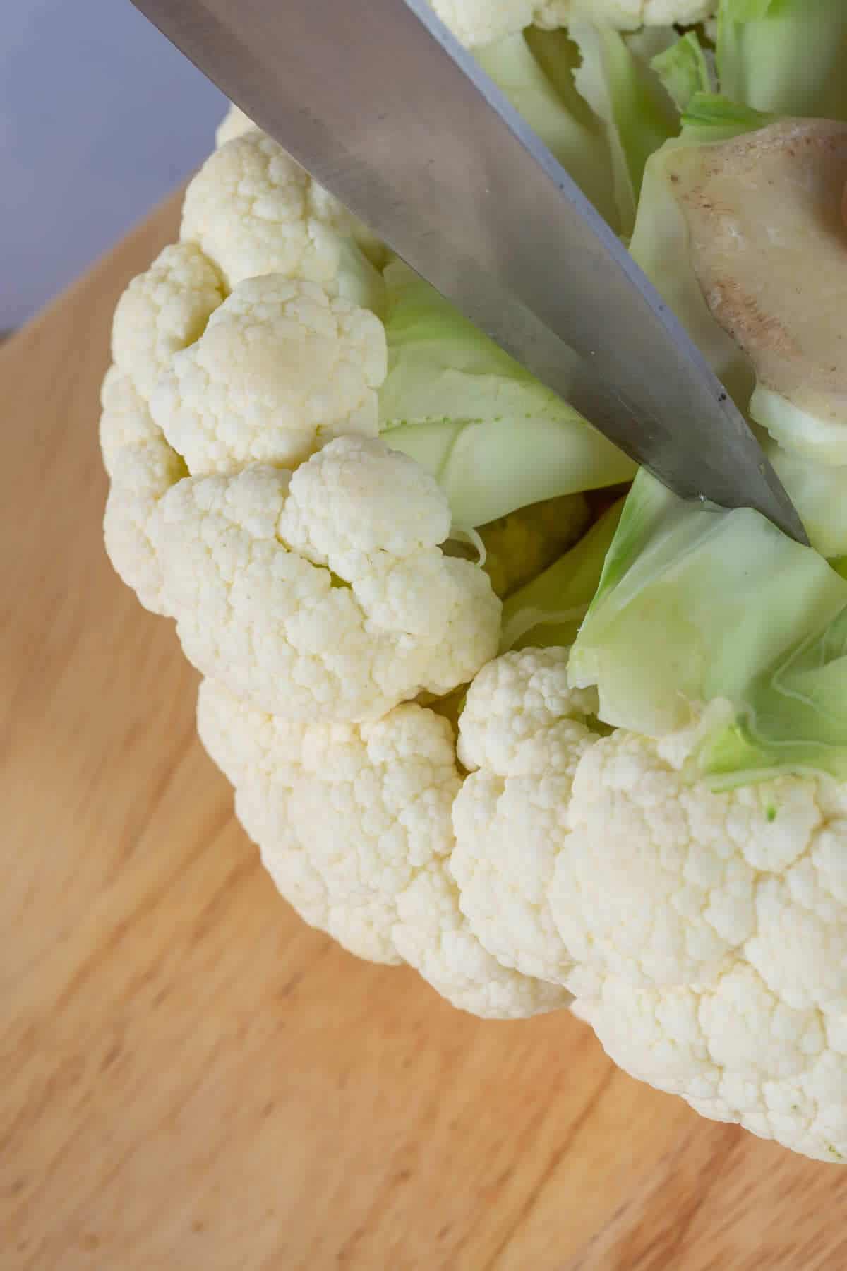 Snipping cauliflower florets from stem.