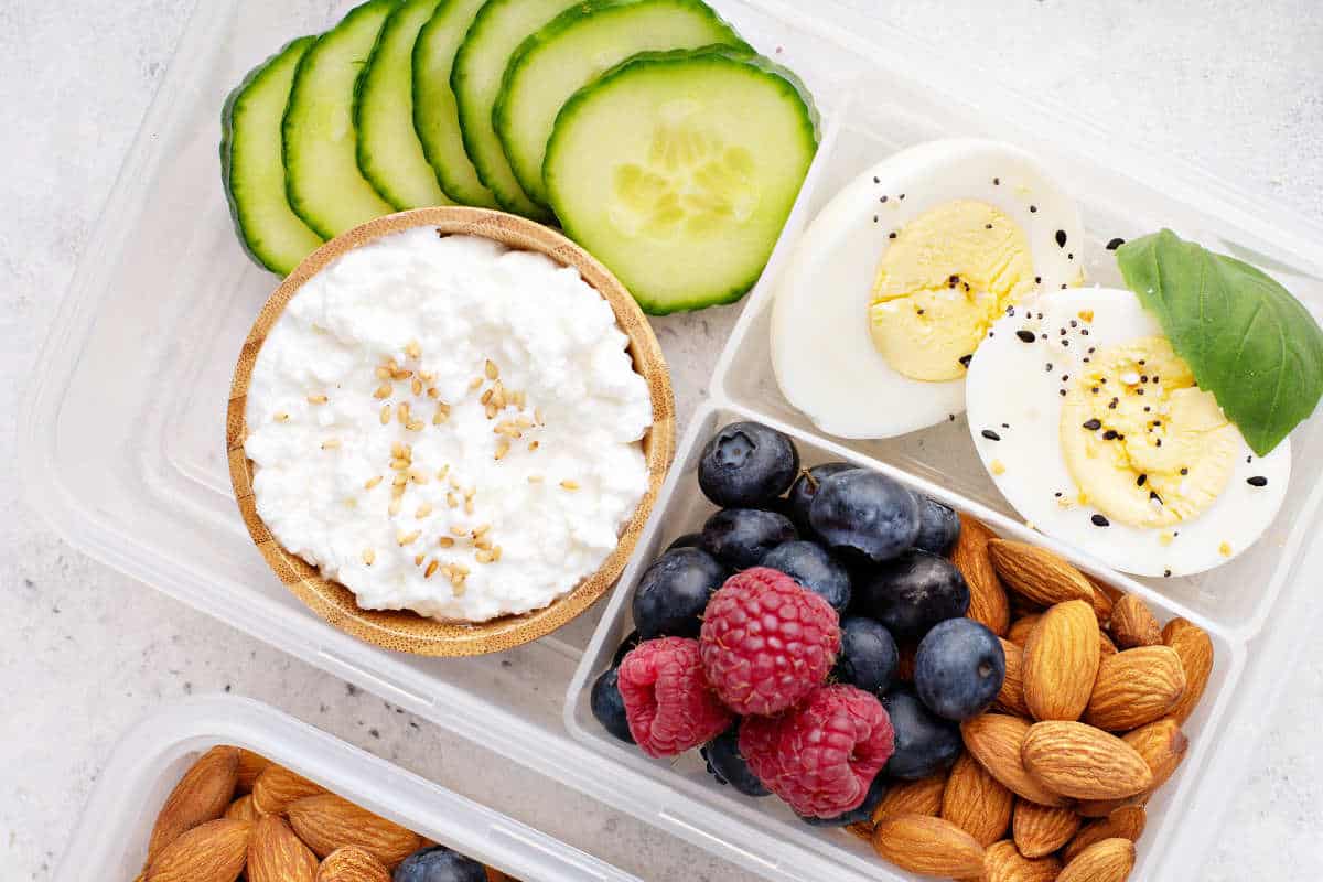 Lunch or snack box with high protein food, cottage cheese, nuts and eggs.