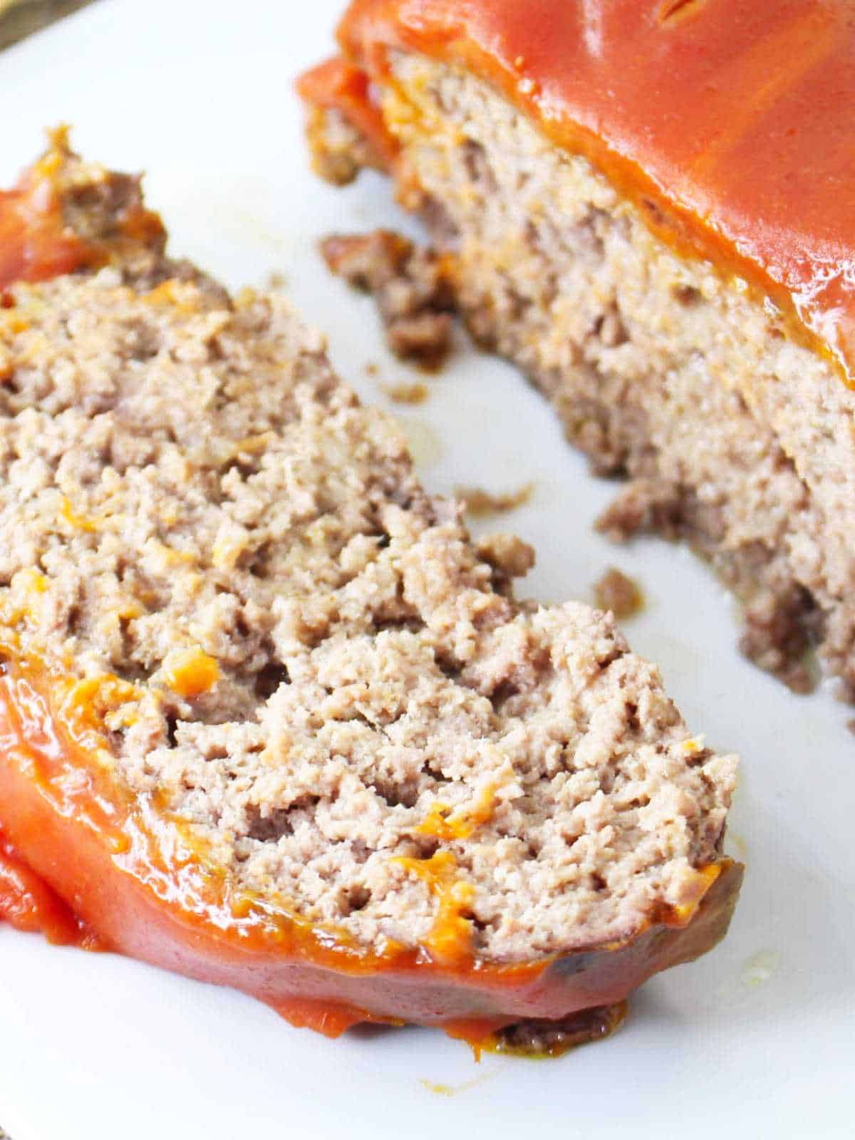 Catsup covered meatloaf on a serving platter with a slice cut. southern meatloaf recipe.