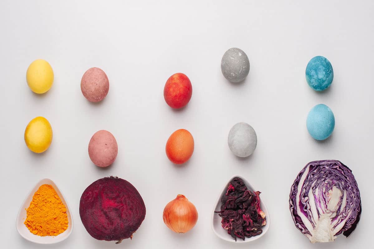 Natural dye for easter eggs - red cabbage, beetroot, hibiscus, turmeric and onion skin on light background Homemade colored Easter eggs with ingredients.