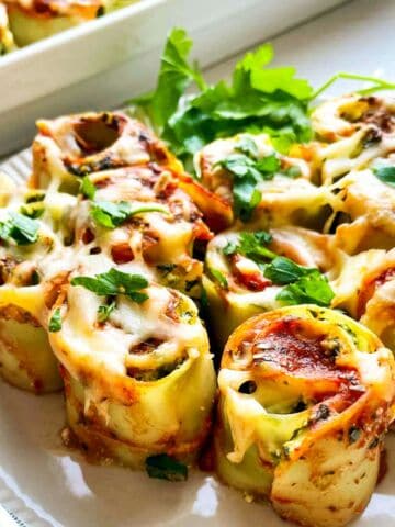 spinach ricotta lasagna rolls on a plate.